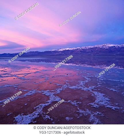 Sunrise reflection in Badwater Basin and Panamint mountains, Death Valley national park, California