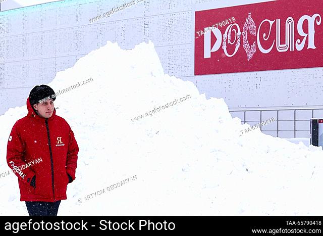 RUSSIA, MOSCOW - DECEMBER 15, 2023: A man walks past a snow pile at the VDNKh exhibition centre and park. Artyom Geodakyan/TASS