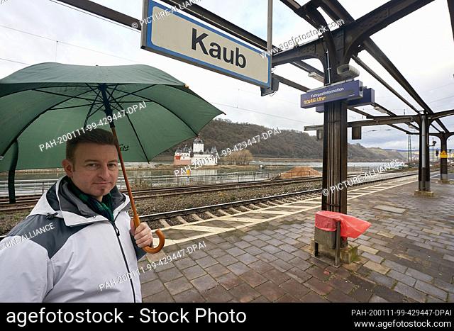10 January 2020, Rhineland-Palatinate, Kaub: The winegrower and hotelier Peter Bahles is standing on the platform of the station with an umbrella