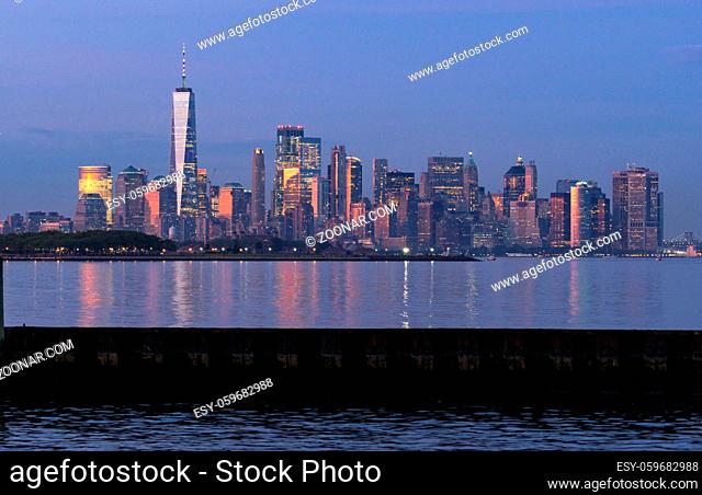 Dusk light reflects off the buildings onto Hudson Bay at sunset in Manhattan