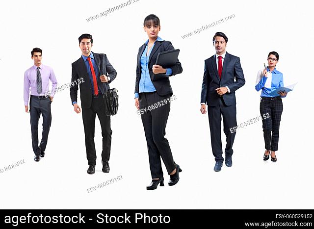 A Team of corporate employees standing at a social distance in formal clothing against white background