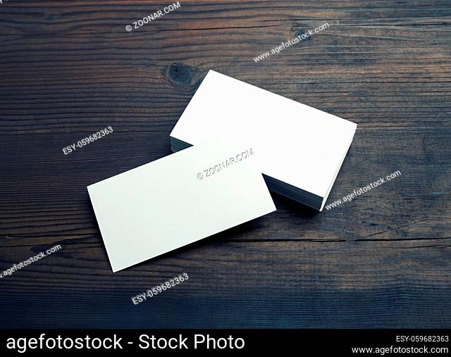 Blank white business cards on wooden background. Mockup for ID. Template for graphic designers portfolios