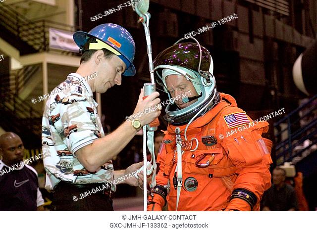 United Space Alliance (USA) crew trainer David Pogue briefs astronaut Steven W. Lindsey, STS-121 commander, on the usage of a climbing apparatus