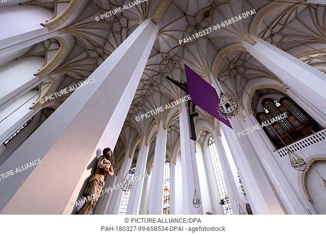 27 March 2018, Germany, Munich: A purple cloth covering the cross in front of the altar in the Munich Frauenkirche. Representations of Jesus are covered in many...