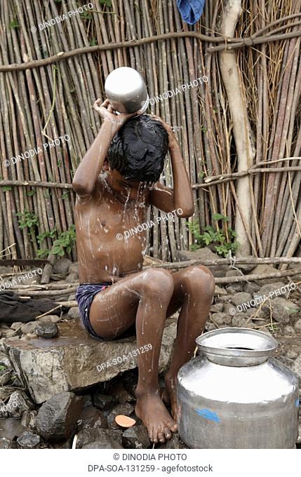 Boy taking bath ; Marathwada ; Maharashtra ; India