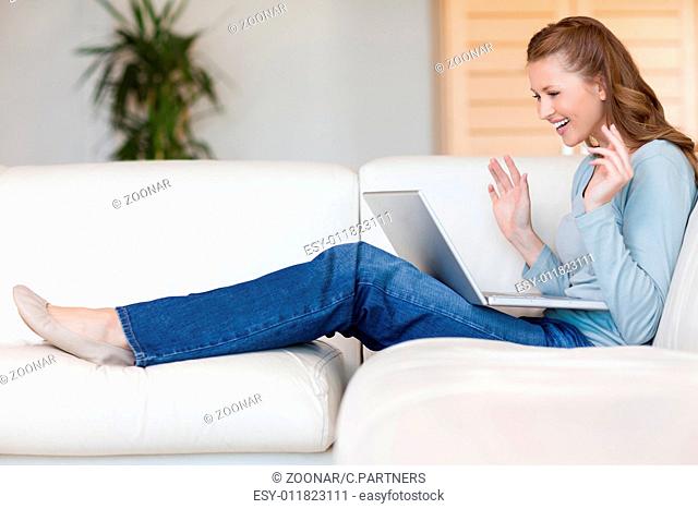 Happy smiling woman on the sofa with her laptop