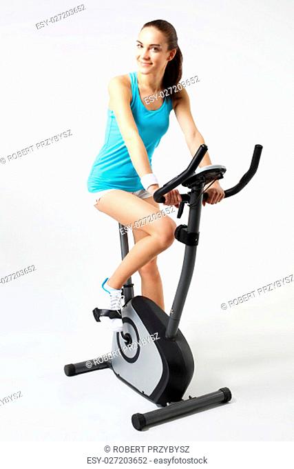 exercise bike, effective form of exercise.\nexercise on a stationary bike, a woman in a fitness club