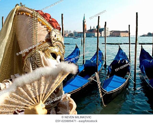 mask and gondola boats waiting for turists in the Venice