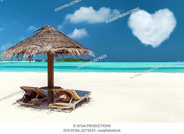 two sunbeds under palapa on maldives beach