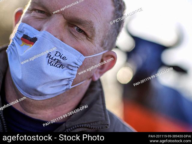 19 November 2020, Mecklenburg-Western Pomerania, Wismar: A dairy farmer with mouth and nose protection and the inscription ""Die faire Milch"" (""The fair...