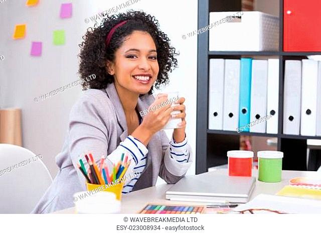 Female interior designer with coffee cup at desk