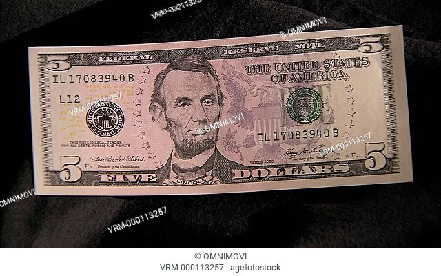 Close up of five dollar note with face of Abraham Lincoln zoom in