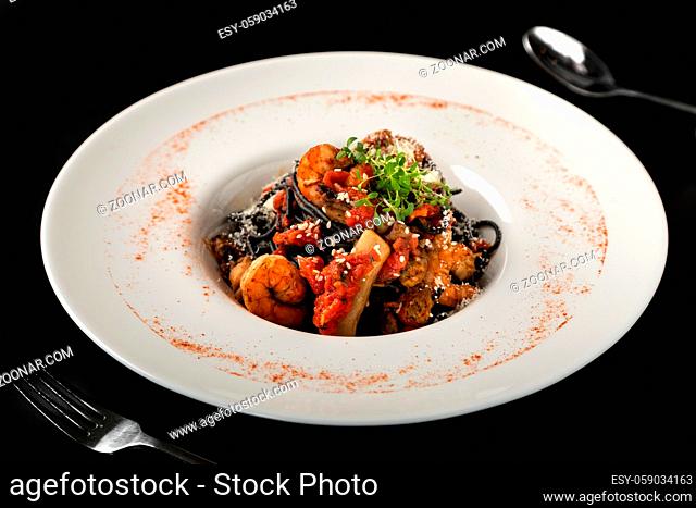 Seafood, Mediterranean cuisine. Black paste with squid ink, with squid meat, crab, shrimp and fish