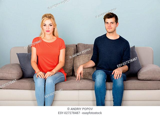 Shy Man Sitting On Couch Flirting With Woman At Home