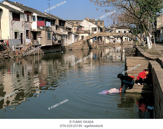 Woman washing clothes in river at Tongli, China