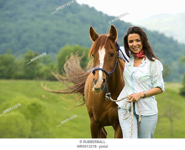 Portrait of a woman standing with a horse