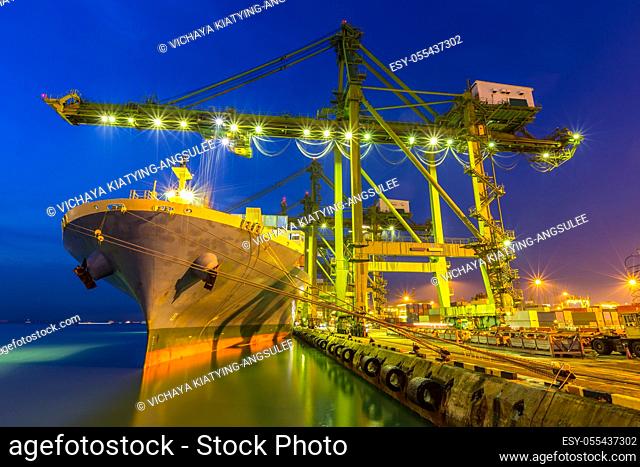 Industrial port with container ship at dusk