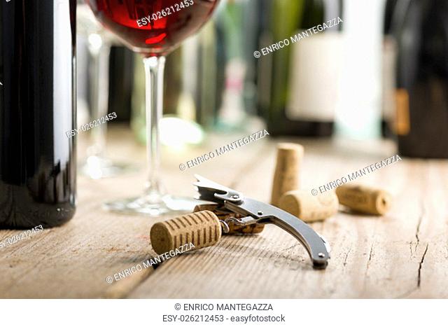 corkscrew with cork inserted near wine glass and bottle
