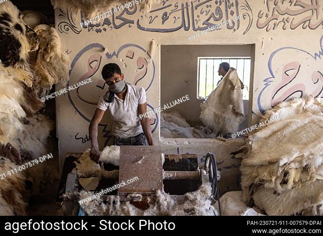20 July 2023, Syria, Azmarin: Syrian workers process cattle hides at a workshop for tanning and natural leather production in the Syrian village of Azmarin