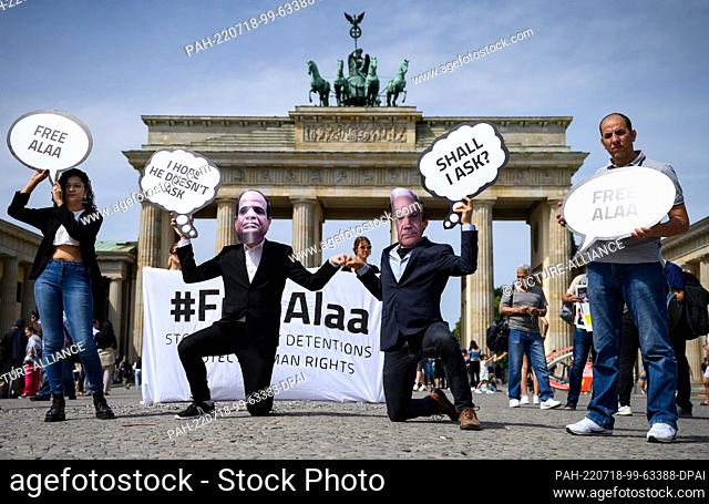 18 July 2022, Berlin: Activists of the non-governmental organization Avaaz protest with masks with the likeness of Chancellor Scholz and President al-Sisi in...