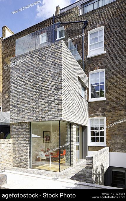 Oblique view of double-height rear extension with corner window on ground level. Queens House, London, United Kingdom. Architect: Paul Archer Design -...