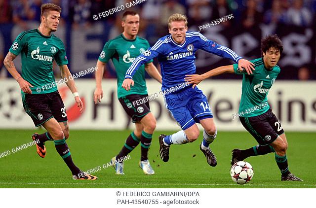 Schalke's Roman Neustaedter (L), Atsuto Uchida (R) and Christian Clemens vie for the ball with Chelsea's Andre Schuerrle (2-R) during the Champions League group...