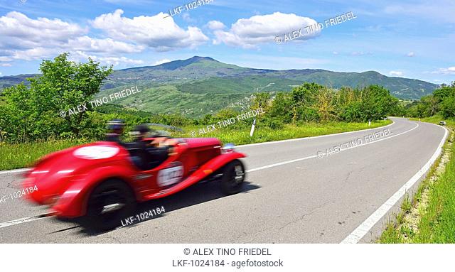 Oldtimer on a road through the Tuscan landscape, Motor Race, Mille Miglia, 1000 Miglia, 2014, Radicofani, Tuscany, Italy, Europe