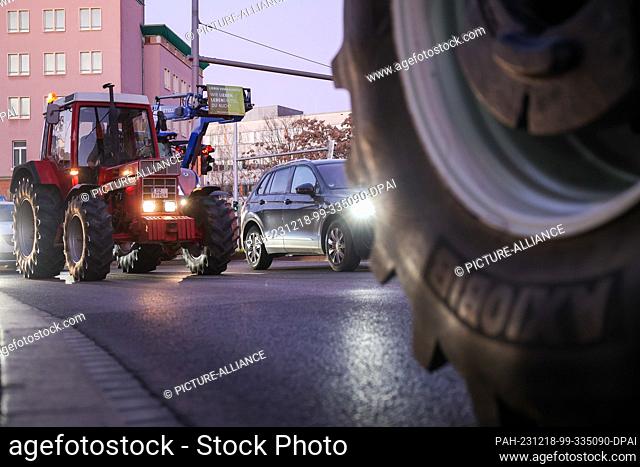 18 December 2023, Saxony, Leipzig: Several farmers drive their tractors through rush-hour traffic in the early morning. Farmers want to mobilize in Berlin on...