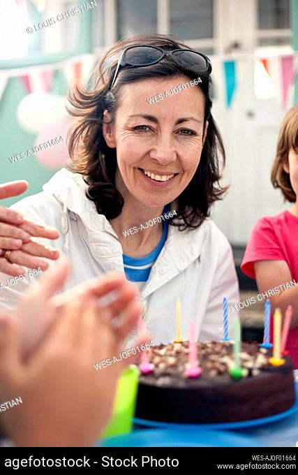 Smiling woman celebrating birthday with family