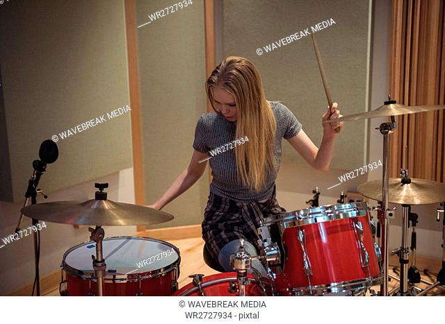 Female drummer playing a playing music on drum set