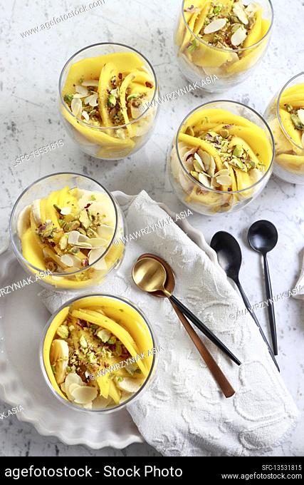 Sugar-free cream dessert with mango, banana, pistachio and almonds