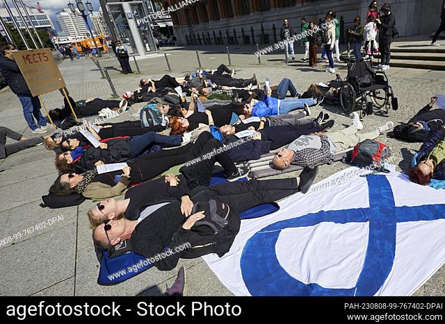 08 August 2023, Berlin: In a reclining demonstration, about fifty demonstrators raise awareness of ME/CFS in front of the Red City Hall