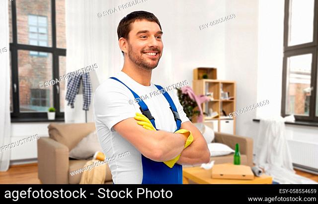 happy male worker or cleaner in gloves at home