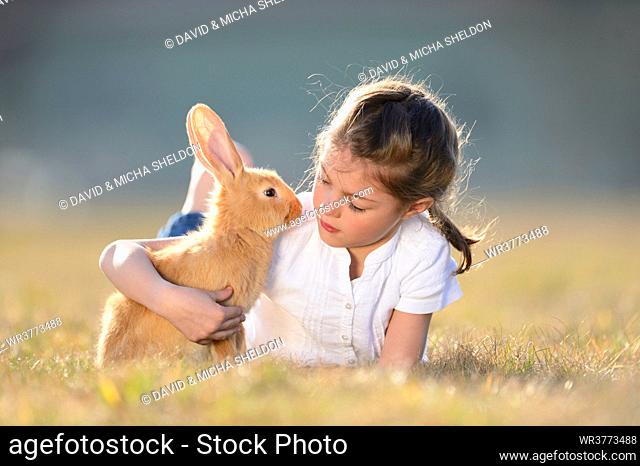 Girl with her rabbit on meadow, Upper Palatinate, Bavaria, Germany, Europe