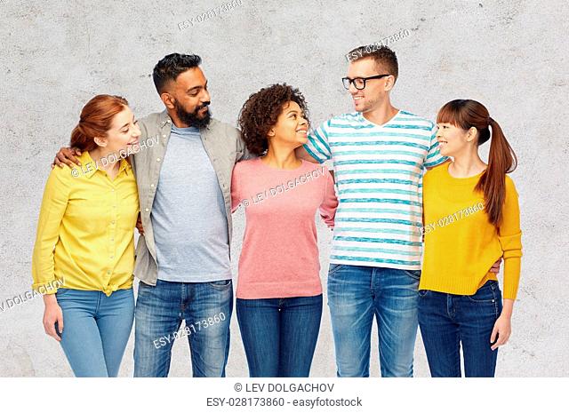 diversity, race, ethnicity and people concept - international group of happy smiling men and women over gray concrete background