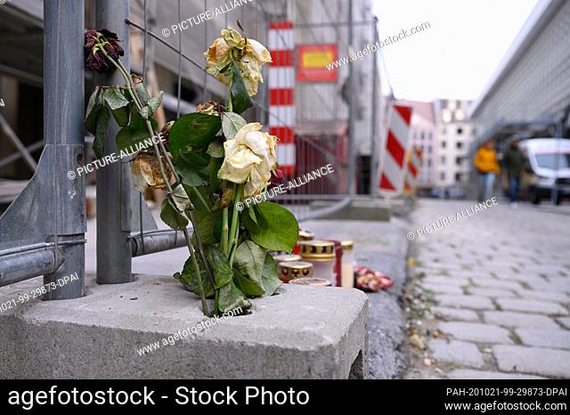 21 October 2020, Saxony, Dresden: Flowers and candles are not far from the Residenzschloss in front of a building fence on Schlossstraße