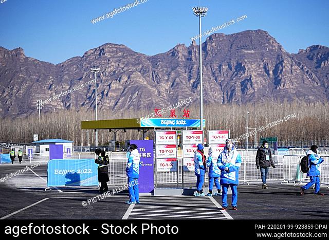 01 February 2022, China, Yanqing: Volunteers and journalists wait at a bus stop. The Beijing Winter Olympics will take place from 04-20.02
