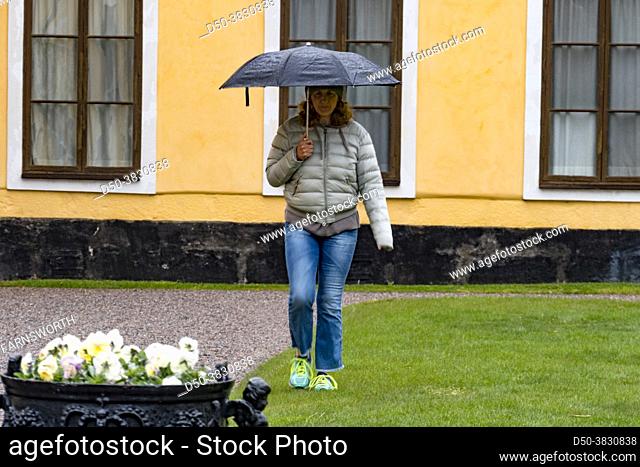 Stockholm, Sweden A woman with an umbrella visits the grounds of the Ulriksdal Palace outside of town