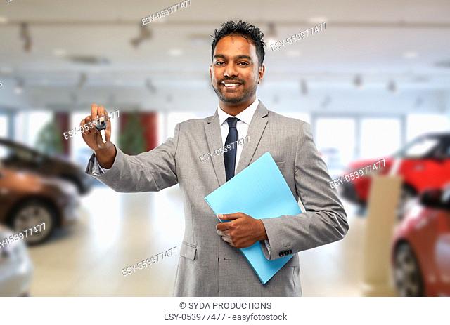 happy indian car dealer with car key at showroom