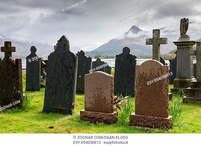 Ballachulish, Scotland - May 6, 2015: Graveyard Ballachulish with old, black gravestones on gras in spring