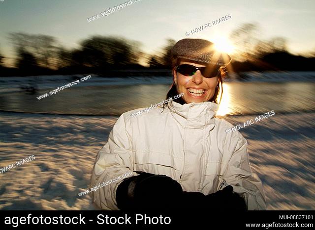 Young woman turns in circle on a frozen lake in city park, Hamburg, Germany, Europe