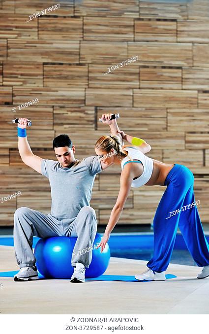 fitness personal trainer on fitness classes supporting group of people and wotrking out together in team