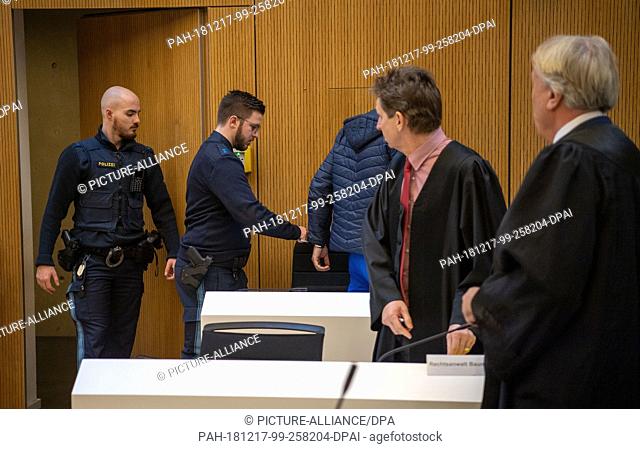 17 December 2018, Bavaria, München: One of the defendants in the Meiling robbery murder trial (3rd from left) is taken to the Stadelheim JVA courtroom