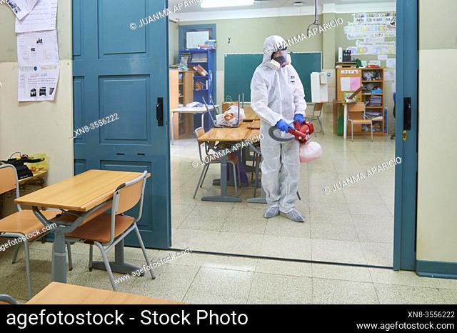 Worker in protective suit disinfect interior of the school