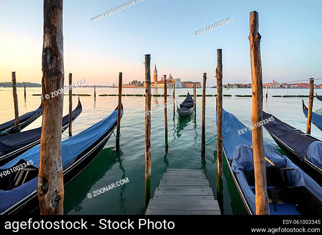 Gondolas moored near pier with the view on San Giorgio Maggiore, Venice