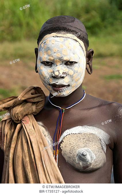 Young Surma woman with facial and body painting and distorted earlobes, Kibish, Omo River Valley, Ethiopia, Africa