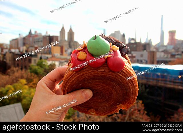 17 November 2023, USA, New York: A woman holds two ""Suprêmes"" - similar to croissants, filled with apple-caramel cream (front) and chocolate cream (back)
