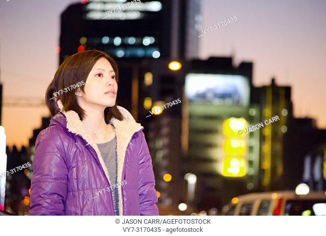 Japanese Girl poses on the street in Aoyama, Japan. Aoyama is a famous area about universities in Tokyo