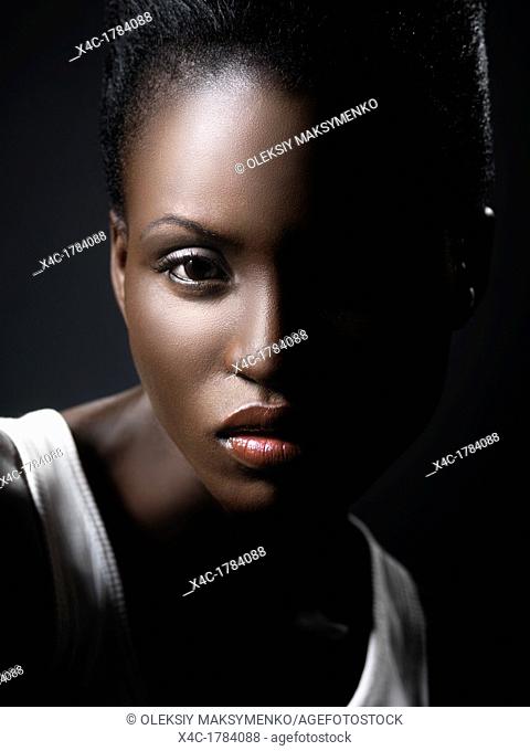 Young black african woman artistic closeup face beauty portrait with dramatic lighting