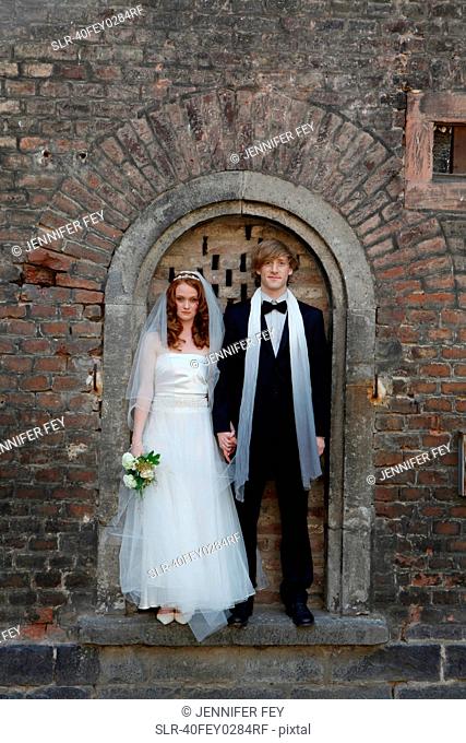 Newlywed couple standing in arch